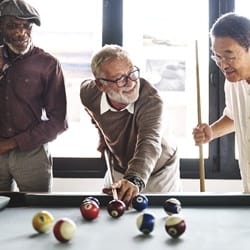 friends playing pool together after denture placement