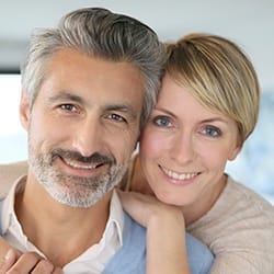 Smiling man and woman after scaling and root planing treatment