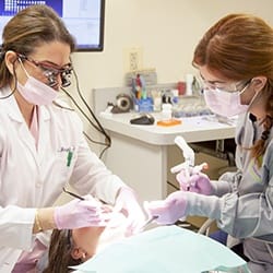 Dentist providing treatment in exam room