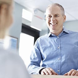 Man smiling at reception administrator