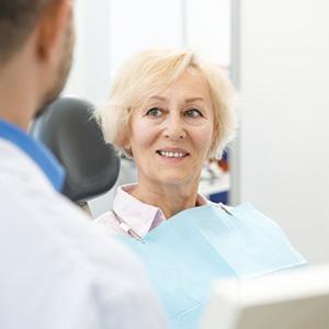 Older woman with blonde hair smiling in dental chair
