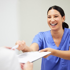 Patient preparing to sign documents in dental office