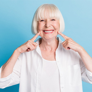 Woman smiling while giving thumbs up in dental chair