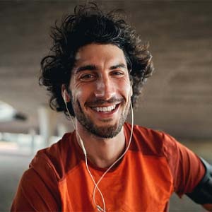 Man smiling under a bridge after visiting emergency dentist in Fairfax, VA