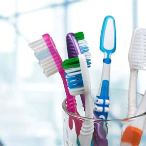 Several toothbrushes in a clear glass