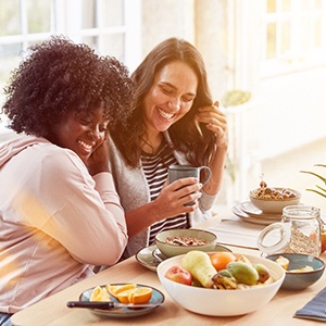 Two friends sitting together and enjoying a healthy breakfast