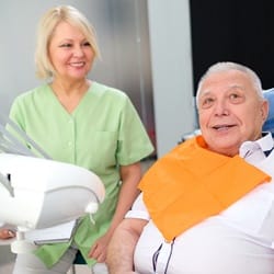 An older patient and dental hygienist discussing the process of dental implant placement in Fairfax