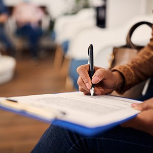 a patient filling out forms on a clipboard