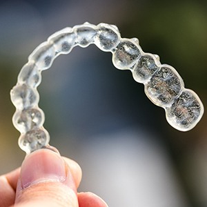 Person holding a clear aligner for Invisalign in Fairfax