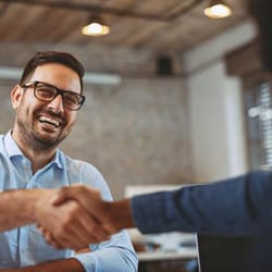 Smiling man shaking hands during Invislaign consultation