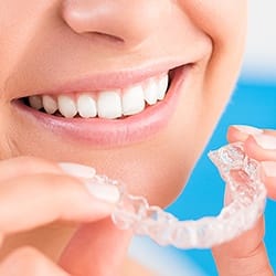 Closeup of patient holding Invisalign tray