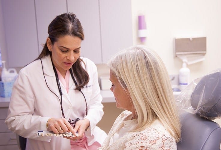 Doctor Ayati talking to patient in dental exam room