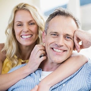 Smiling man and woman after periodontal therapy