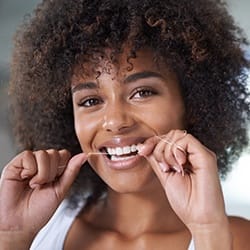 Woman flossing teeth