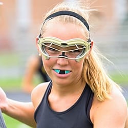 Teen girl wearing sportsguard playing lacrosse