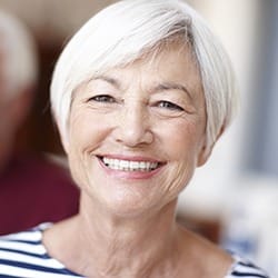 Senior woman with flawless smile after denture tooth replacement