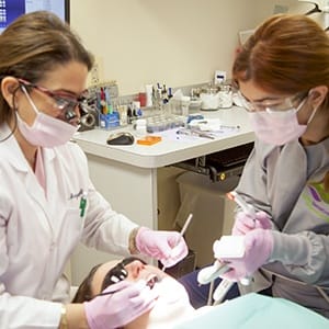 Dr. Ayati and dental assistant treating patient using advanced dental services and technology