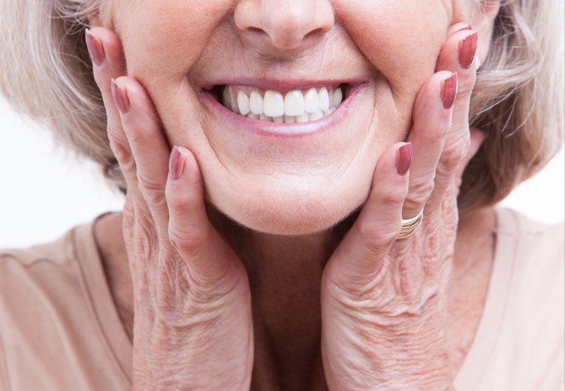 woman smiling with a white set of dentures