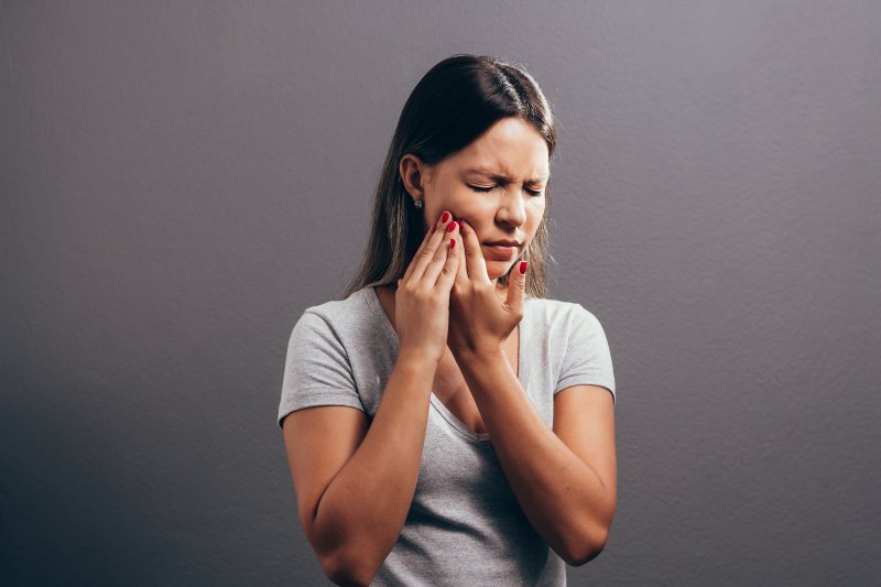A woman experiencing facial pain