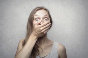 Woman in shock with her hand over her mouth
