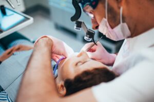 Dentist performing root canal on patient. 